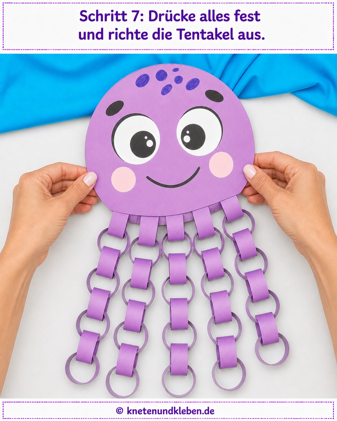 Hände drücken den fertigen Papieroktopus fest und richten die Kettenglieder-Tentakel gerade aus
