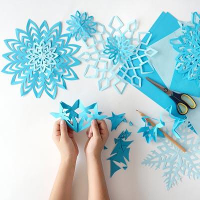 Kinder schneiden Papier Schneeflocken