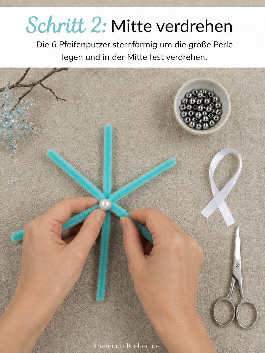 Sechs Pfeifenputzer werden sternförmig um eine große Perle verdreht für die Schneeflocke
