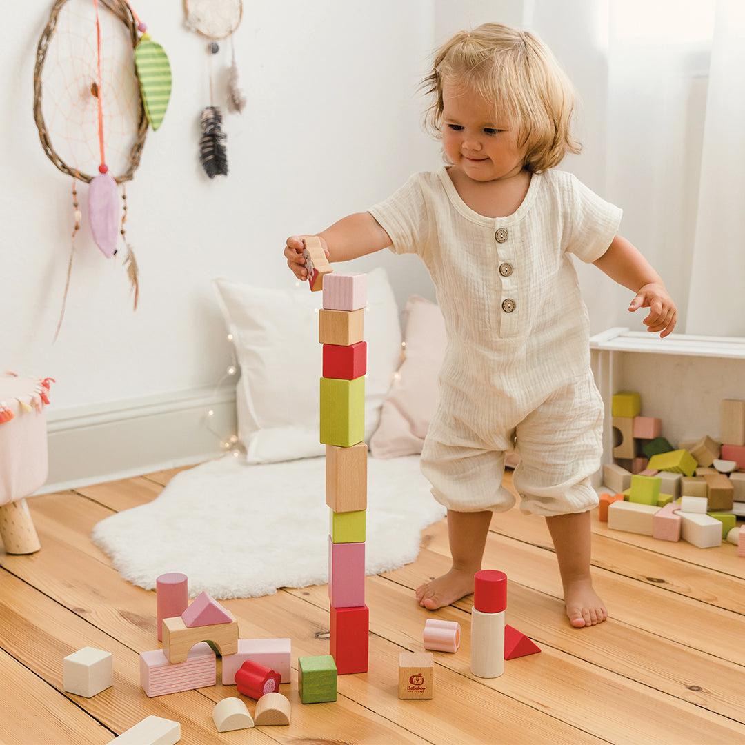 Kind baut Turm mit Bauklötzen